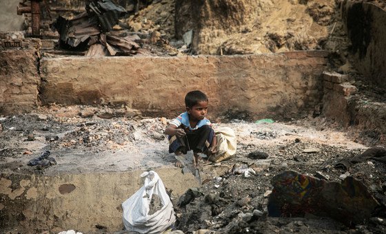a child rummages through debris after a massive fire devastated